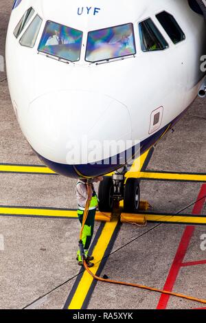 Mitarbeiter des Flughafens, eine Schürze Arbeiter mit einem elektrischen Kabel das Flugzeug aufzuladen, Flughafen Düsseldorf International, Düsseldorf Stockfoto