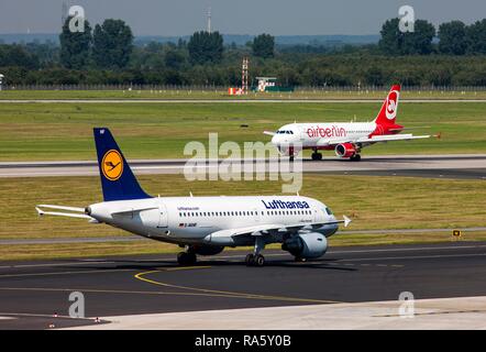 Ein Lufthansa Airbus A319 auf dem Rollfeld und eine Air Berlin Airbus A 320 nach der Landung am Flughafen Düsseldorf International Stockfoto