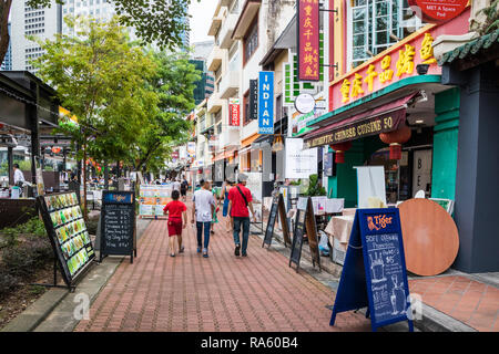 Singapur - 14. Dezember 2018: die Menschen zu Fuß vorbei an Restaurants und Bars auf der Boat Quay. Die Straße ist sehr beliebt bei Touristen und Expats. Stockfoto