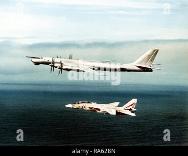 1977 - Ein Luft-zu-Luft linke Seitenansicht eines sowjetischen Tu-95 Bear A/B Flugzeug wie eine F-14 Tomcat Flugzeug fängt es. Stockfoto