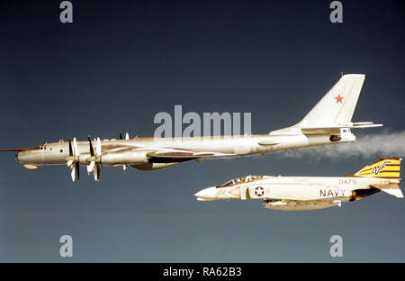 1974 - Ein Luft-zu-Luft linke Seitenansicht eines sowjetischen Tu-95 Bear D Flugzeuge wie die F-4 Phantom II Flugzeuge aus Jagdgeschwader 151 (VF-151) abfängt. Stockfoto