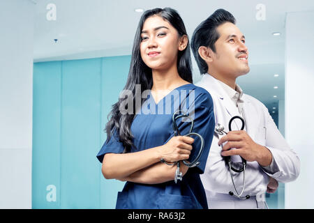 Jungen asiatischen medizinischen Personal zurück stehend mit holding Stethoskop im Krankenhaus zurück Stockfoto