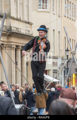 Badewanne, Großbritannien. 1. Jan 2019. Eine street Entertainer spielt seine Violine während einen Seiltänzer im Zentrum von Bath, England am ersten Tag von 2019 als Massen von Käufern die meisten der neuen Jahre Tag Umsatz machen. Credit: Phil Rees/Alamy leben Nachrichten Stockfoto