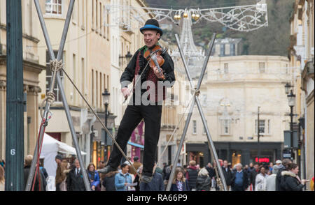 Badewanne, Großbritannien. 1. Jan 2019. Eine street Entertainer spielt seine Violine während einen Seiltänzer im Zentrum von Bath, England am ersten Tag von 2019 als Massen von Käufern die meisten der neuen Jahre Tag Umsatz machen. Credit: Phil Rees/Alamy leben Nachrichten Stockfoto