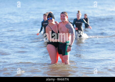 1. Januar 2019, Scarborough, North Yorkshire, UK. Die neuen Jahre Tag Schwimmen in der Nordsee, die von Scarborough Lions ausgeführt wird und hebt Geld für gute Zwecke. Die milden Temperaturen sahen 1000 Zuschauer zu beobachten 100 von Schöpflöffel das kalte Wasser trotzen. Credit: Yorkshire Pics/Alamy leben Nachrichten Stockfoto