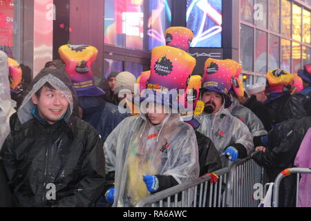 Die Teilnehmer sind im Times Square Sylvester feiern das neue Jahr gesehen. Trotz den ganzen Tag Regen, mehr als 2 Millionen Menschen am Silvesterabend das Neue Jahr am Times Square beteiligen. Stockfoto