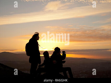 Edinburgh, Schottland, Großbritannien. 2. Januar 2019. UK Wetter, Touristen genießen die Aussicht von Arthur's Seat Gipfel in Holyrood Park gleich um Sonnenuntergang, obwohl die Temperatur minus 1 Grad nach einer Nacht von minus sechs Grad. Stockfoto