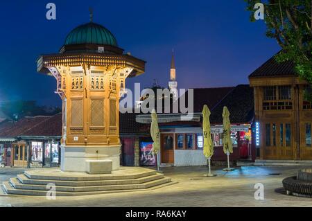 Beleuchtete Sebilj im osmanischen Stil Holz- Brunnen bei Sonnenaufgang, Bascarsija alten Bazar, Sarajevo, Bosnien und Herzegowina Stockfoto