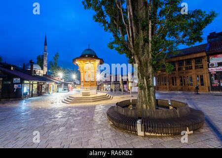 Beleuchtete Sebilj im osmanischen Stil Holz- Brunnen bei Sonnenaufgang, Bascarsija alten Bazar, Sarajevo, Bosnien und Herzegowina Stockfoto