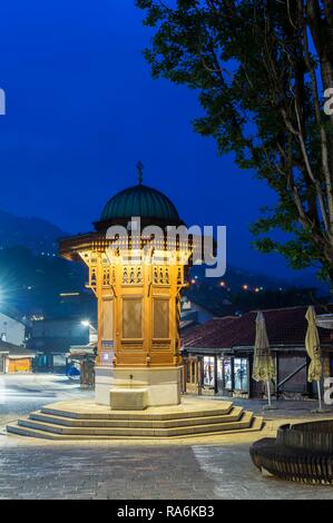 Beleuchtete Sebilj im osmanischen Stil Holz- Brunnen bei Sonnenaufgang, Bascarsija alten Bazar, Sarajevo, Bosnien und Herzegowina Stockfoto