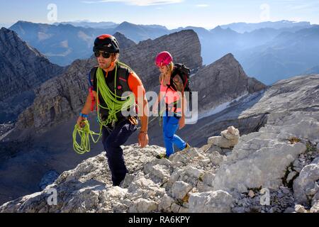 Bergführer führt eine junge Frau auf einem kurzen Seil durch eine Felswand, Wiederroute, Watzmann, Schönau am Königssee Stockfoto