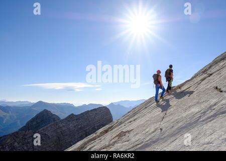 Bergführer führt eine junge Frau auf einem kurzen Seil durch eine Felswand, Wiederroute, Watzmann, Schönau am Königssee Stockfoto