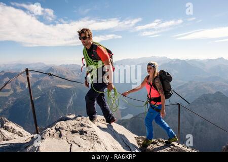 Bergführer führt eine junge Frau auf einem kurzen Seil durch einen Klettersteig, Watzmann, Schönau am Königssee Stockfoto