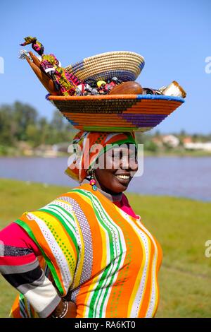 Senegalesische Frau in Buntes Kleid mit Waren auf dem Kopf, Lac Rose, Dakar, Senegal Stockfoto