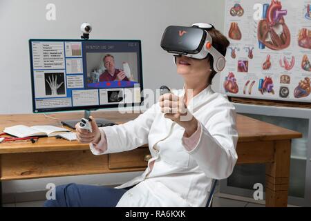 Symbol Foto für Telemedizin, Arzt in einer Praxis, mit VR-Brille, Virtual Reality, 3D-Darstellung eines MRT-Ergebnis, Stockfoto