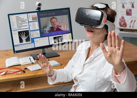 Symbol Foto für Telemedizin, Arzt in einer Praxis, mit VR-Brille, Virtual Reality, 3D-Darstellung eines MRT-Ergebnis, Stockfoto