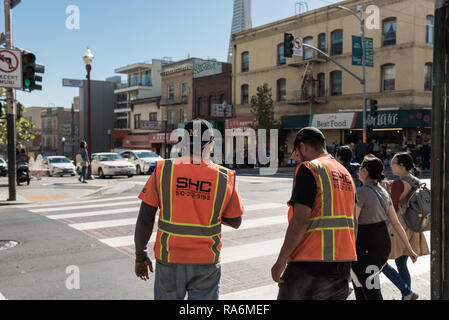 Arbeitnehmer mit orangefarbenen Westen warten eine Straße in San Francisco, Kalifornien, USA zu überqueren Stockfoto