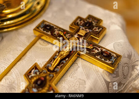 Goldenes orthodoxes Kreuz mit Jesus auf strukturierte Tabelle Stockfoto
