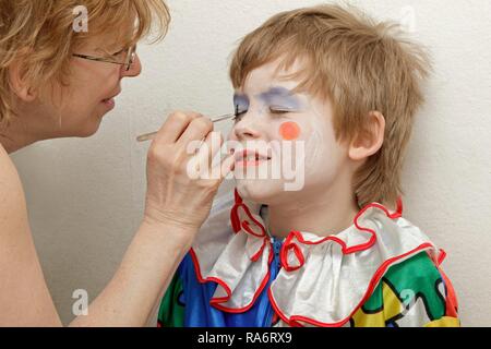 Little Boy gekleidet wie ein Clown, wird von seiner Mutter gemacht Stockfoto