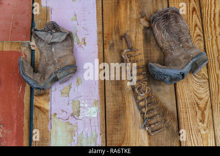 Alte Cowboy Stiefel gegen raue Holz Hintergrund Stockfoto
