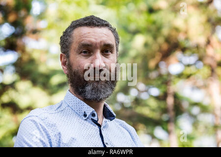 Portrait von Stattlichen 40 Jahre alter Mann mit lockigem Haar und bunt. Stockfoto