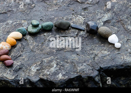 Arch von bunten Felsen auf einer Steinplatte Stockfoto