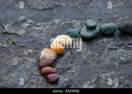 Strudel der bunten Felsen auf einer Steinplatte Stockfoto