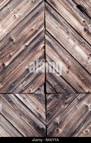 Closeup Detail der dekorativen rustikale Holzarbeiten und Nägel mit natürlichen verwitterten dunklen vintage Holz auf einem ländlichen Bauernhof Fassade - antike Hintergrund Stockfoto