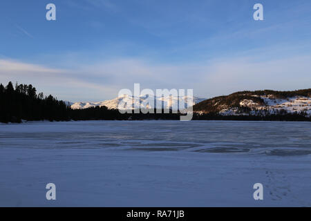 Snowy Mountains Rising vom See Stockfoto