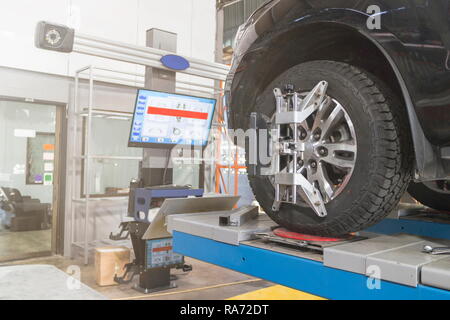 Ein Auto auf dem Auto Lenkrad Balancer und kalibrieren Sie mit Laser Reflektor befestigen Sie auf jedem Reifen Center fahren Sie in der Garage einstellen. Stockfoto