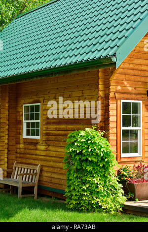 Eine vertikale Bild eines schönen Blockhaus im glänzenden Sub von Sommer in ländlichen Alberta, Kanada. Stockfoto