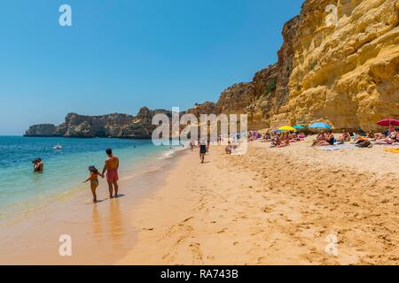 Die badegäste am Sandstrand, türkisblaues Meer, Praia da Marinha, Schroffe Felsenküste von Sandstein, Felsformationen im Meer Stockfoto