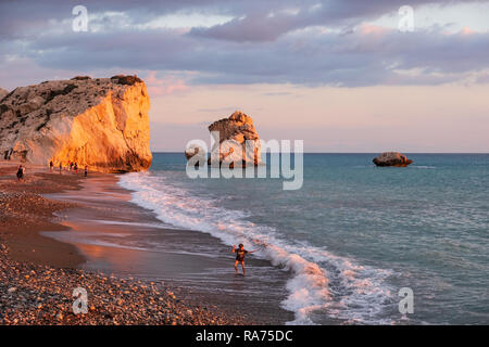 Paphos, Zypern - November 24, 2018: Ein Junge spielt in der Strand von Petra tou Romiou Felsen, in Paphos, Zypern. Der Strand gilt als Aphrodite zu sein Stockfoto