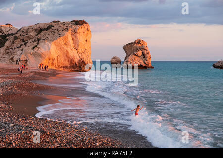 Paphos, Zypern - November 24, 2018: Ein Junge spielt in der Strand von Petra tou Romiou Felsen, in Paphos, Zypern. Der Strand gilt als Aphrodite zu sein Stockfoto