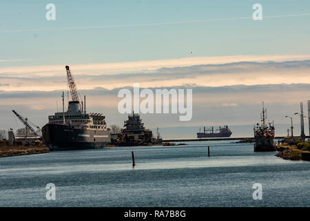 Ein Schiff verlässt die Welland Canal am Lake Erie in Port Colborne, auf der Linken, Schiffen, die von Marine Recycling Corporation Port Colborne geborgen werden. Stockfoto