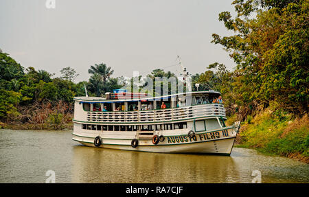 Santarem, Brasilien - Dezember 02, 2015: weiße Schiff mit Passagieren auf Deck fließenden Fluß am grauen Himmel auf natürlichen Hintergrund. Wasser, Verkehr und Reisen. Reiseziel Konzept. Sommer Urlaub. Stockfoto