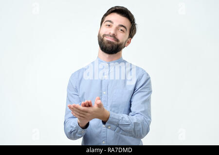 Hübscher junger spanischer Mann mit Bart in blaues Hemd applaudieren Stockfoto
