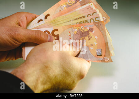 Mann Hand, die Haufen von 50 Euro Rechnungen Reichtum in einem Geschäft zu zeigen. Stockfoto