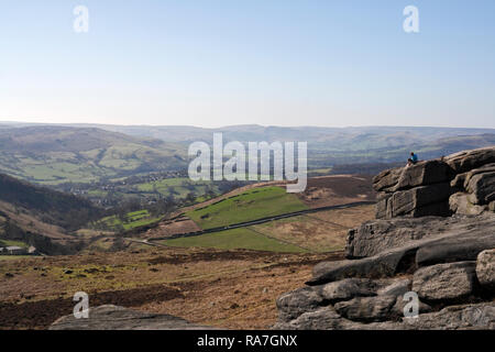 Blick auf das Hope-Tal im Peak District National Park England UK, vom Higger Tor, und Kletterer, die auf der malerischen Felsenlandschaft sitzen Stockfoto