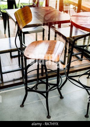 Holz- Vintage Bar Hocker mit schwarzem Stahl Beine im Cafe vertikale Stil. Stockfoto