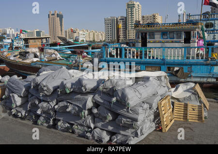 Dubai, Vereinigte Arabische Emirate - November 03, 2018. Die Rückseite der Seehafen. Eine kleine private no name Handelsschiff leert Taschen mit mit Rollen o Stockfoto