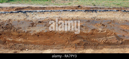 Querschnitt der Fahrbahn mit Schichten von Ton, Sand und Asphalt. Panoramablick auf die Collage aus mehreren outdoor Fotos Stockfoto