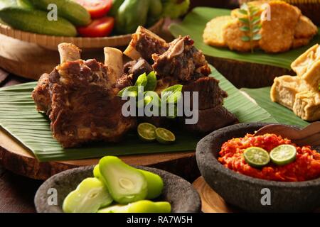 Iga Penyet. Javanisch gebraten - dann - zertrümmerte Rindfleisch Rippen mit roter Chili Paste und frischem Gemüse serviert. Stockfoto