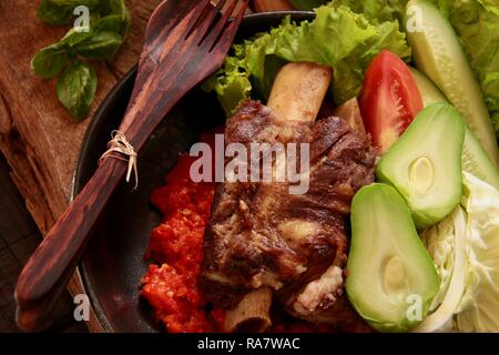 Iga Penyet. Javanisch gebraten - dann - zertrümmerte Rindfleisch Rippen mit roter Chili Paste und frischem Gemüse serviert. Stockfoto