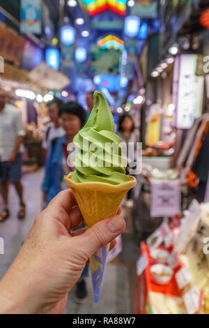 Nahaufnahme einer Hand, die Grünen weichen dienen oder Matcha grüner Tee Eis im japanischen Markt Stockfoto