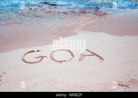 Wort Goa auf dem Sand am Strand bei Sonnenuntergang Stockfoto
