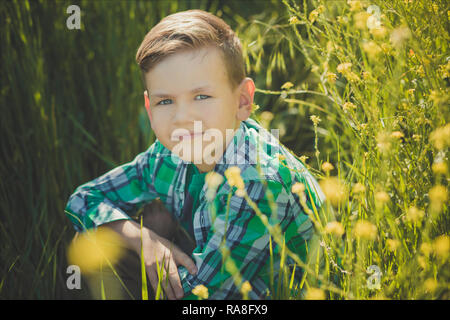 Schöner Junge mit blonden Haaren im Rapsfeld. Stockfoto