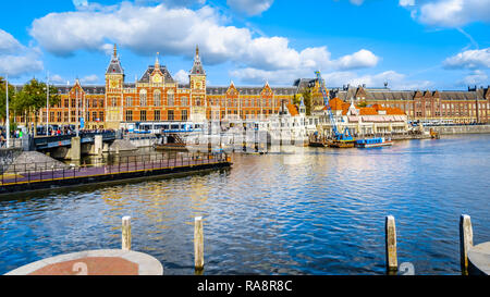 Die berühmten Hauptbahnhof mit der touristischen Kanalboote in der Oosterdokgracht im Stadtzentrum von Amsterdam in den Niederlanden Stockfoto