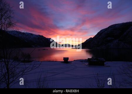 Atemberaubenden Sonnenaufgang über See und Berge mit Hütte Silhouette Stockfoto