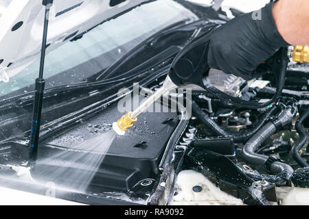 Von Autoteilen. Manuelle Waschen mit Wasser unter Druck. Waschen auto motor mit Wasser Düse. Auto washman Arbeiter Reinigung Automobil. Mann spritzen p Stockfoto